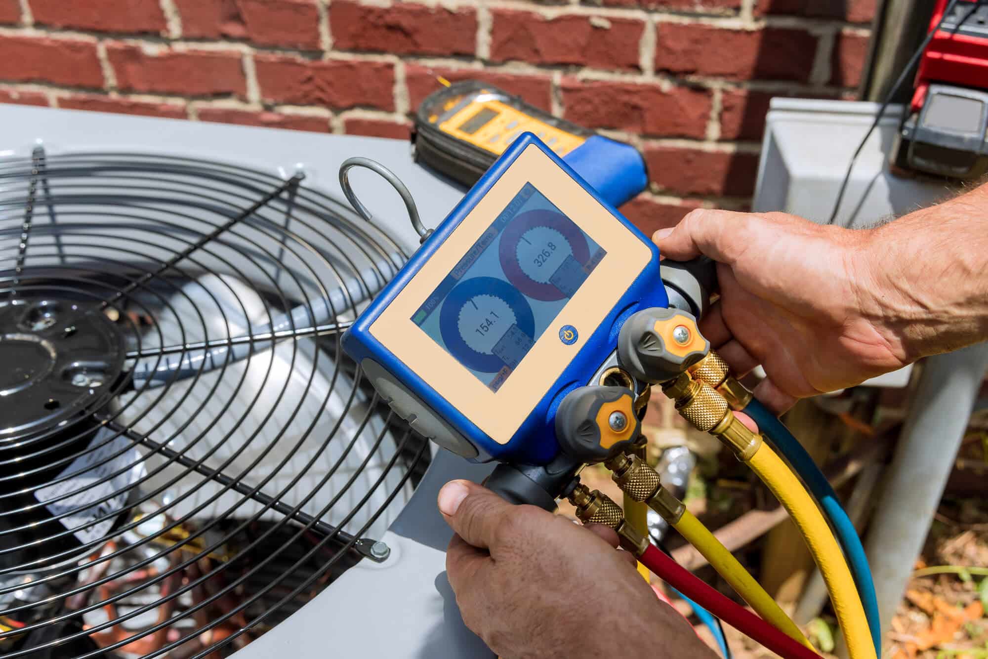 HVAC gauges connected during outdoor condenser maintenance