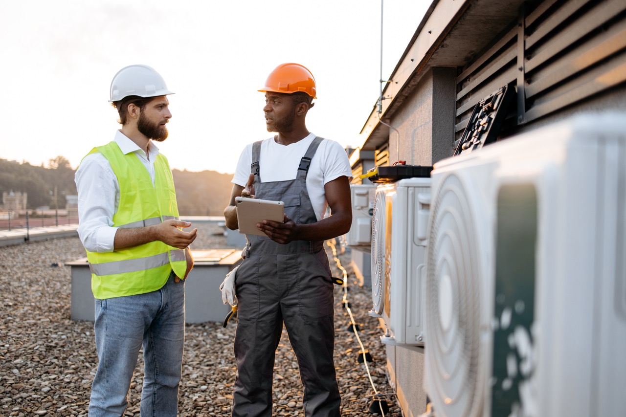 Commercial HVAC specialists reviewing rooftop equipment
